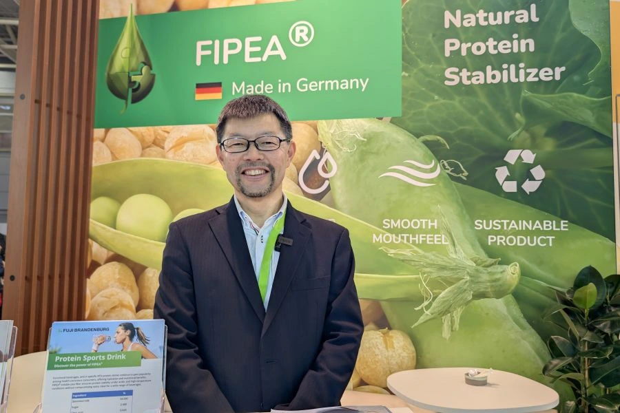 scott kato stands in front of the booth at FiE.